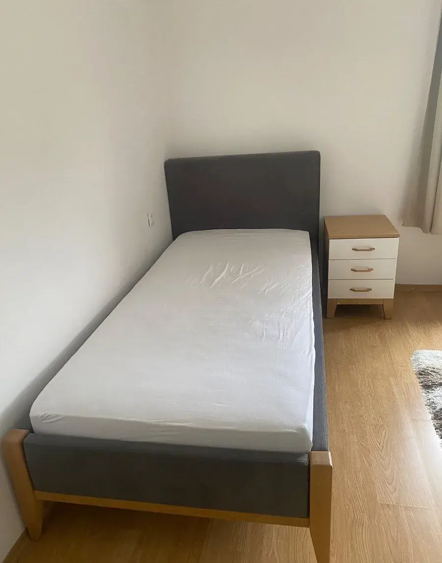 čalunená posteľ s nočným stolíkom